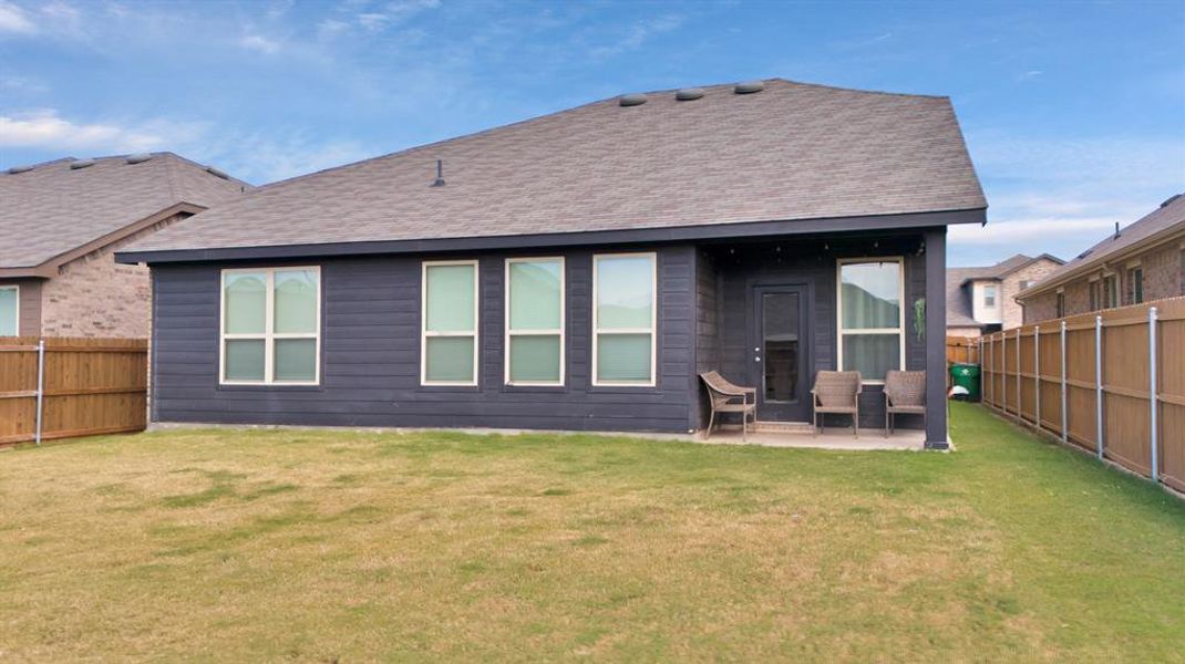 Rear view of house featuring a lawn and a patio