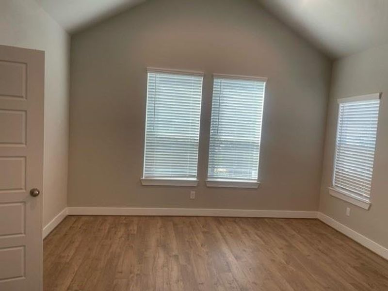 Primary bedroom has a vaulted ceiling