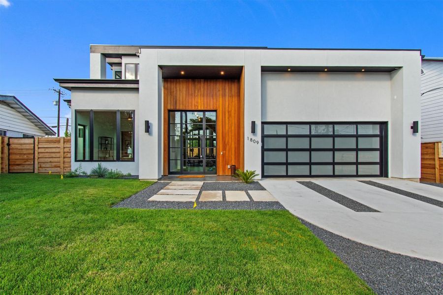 Discover modern elegance with a striking facade, warm wood accents, and an inviting entrance that sets the tone for luxury living.