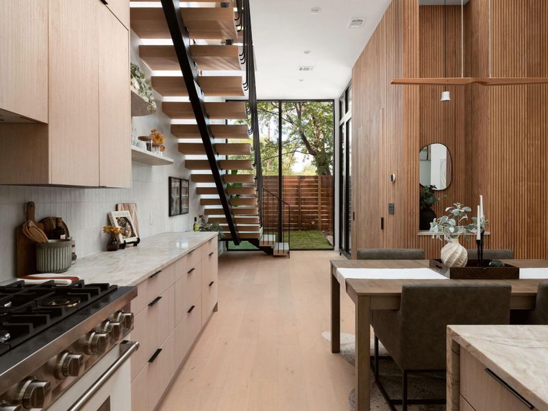Natural wood tones and clean lines define this open-concept culinary and dining space.