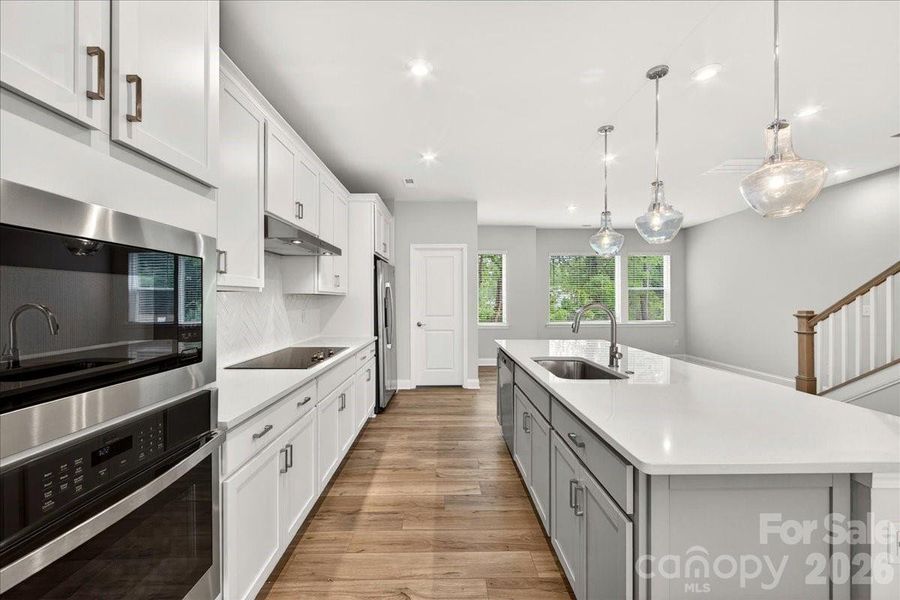 Gourmet kitchen with dual tone cabinets with a grey island Gourmet kitchen with dual tone cabinets with a grey island