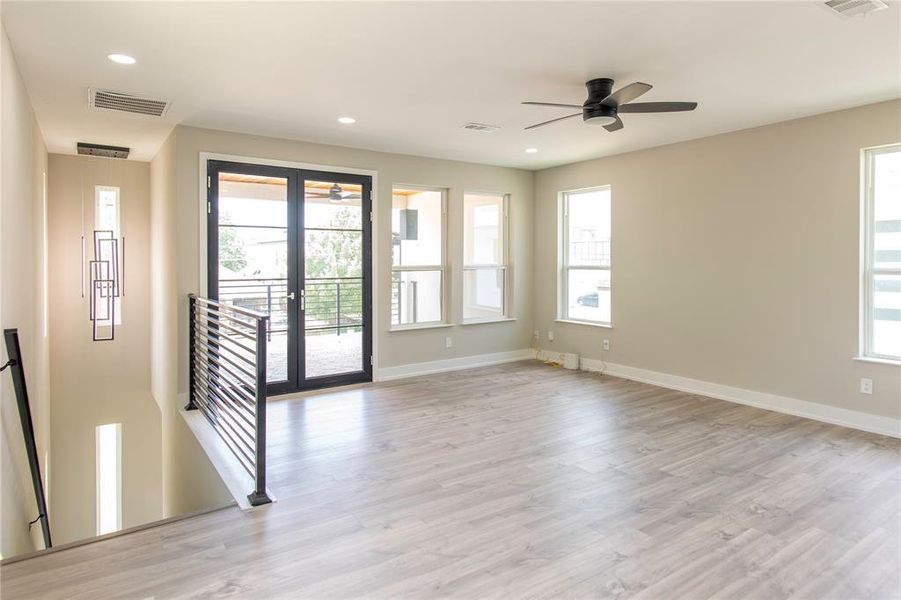 Spare room featuring ceiling fan, french doors, and light wood-type flooring