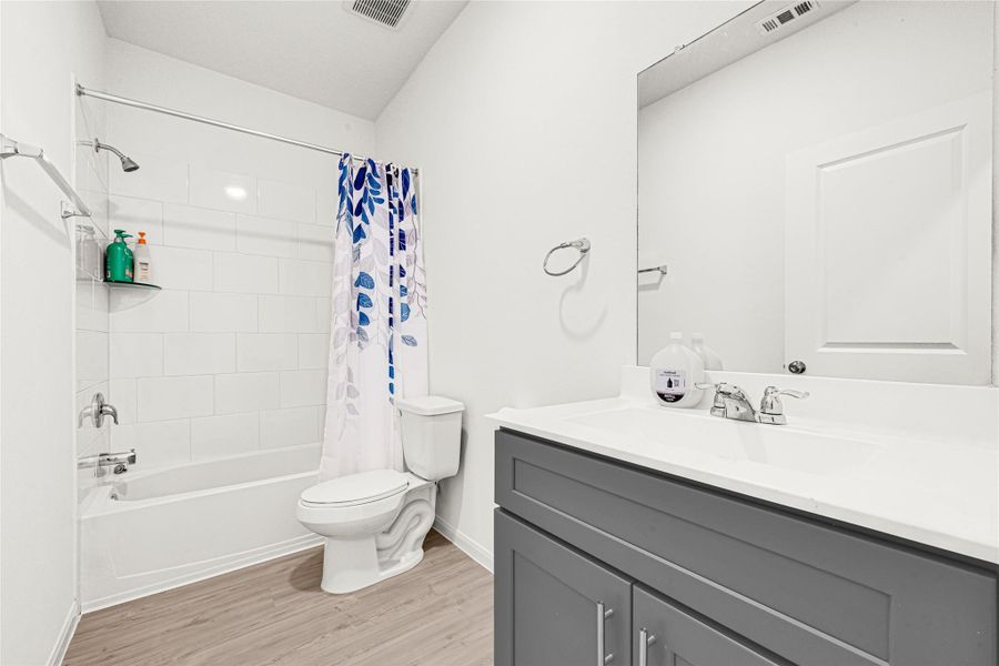 Modern bathroom showcasing a dark wood vanity with dual sinks and updated fixtures.
