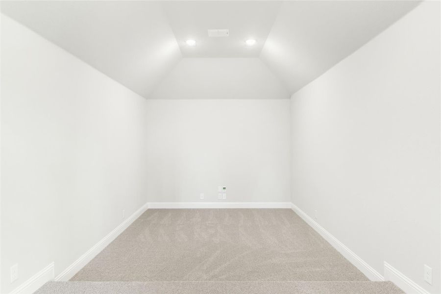 Empty room with vaulted ceiling, recessed lighting, white walls, and beige carpet Empty room with vaulted ceiling, recessed lighting, white walls, and beige carpet