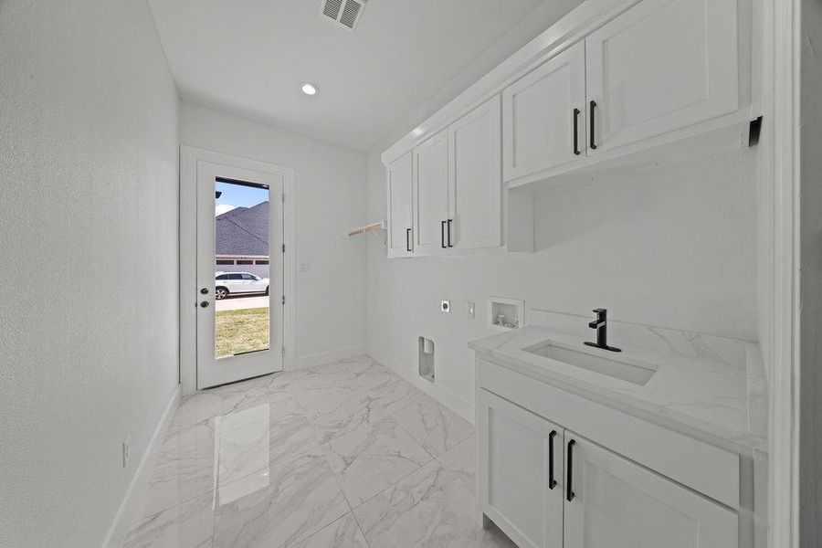 Laundry room featuring hookup for a washing machine, cabinet space, light marble finish flooring, electric dryer hookup, and recessed lighting