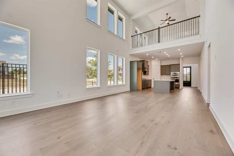 Unfurnished living room with light wood-style floors, ceiling fan, and beamed ceiling Unfurnished living room with light wood-style floors, ceiling fan, and beamed ceiling