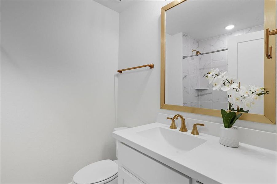 Upstairs ensuite bathroom with shower / tub combo and vanity with gold touches Upstairs ensuite bathroom with shower / tub combo and vanity with gold touches