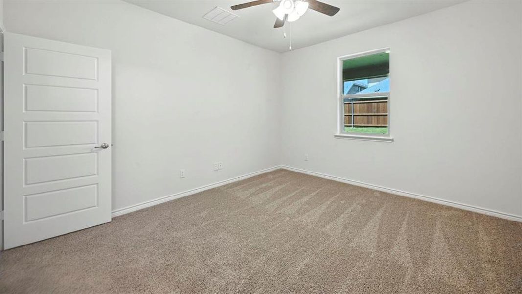 Carpeted spare room with baseboards and ceiling fan Carpeted spare room with baseboards and ceiling fan
