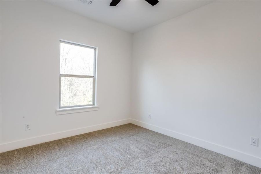 Spare room featuring carpet flooring and ceiling fan