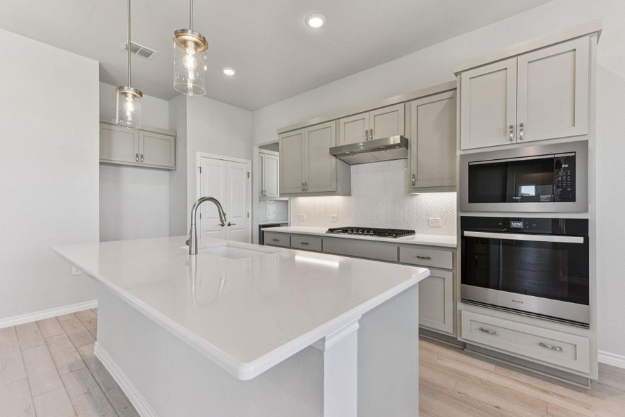 Kitchen featuring stainless steel appliances, tasteful backsplash, gray cabinetry, light wood-style flooring, and recessed lighting Kitchen featuring stainless steel appliances, tasteful backsplash, gray cabinetry, light wood-style flooring, and recessed lighting
