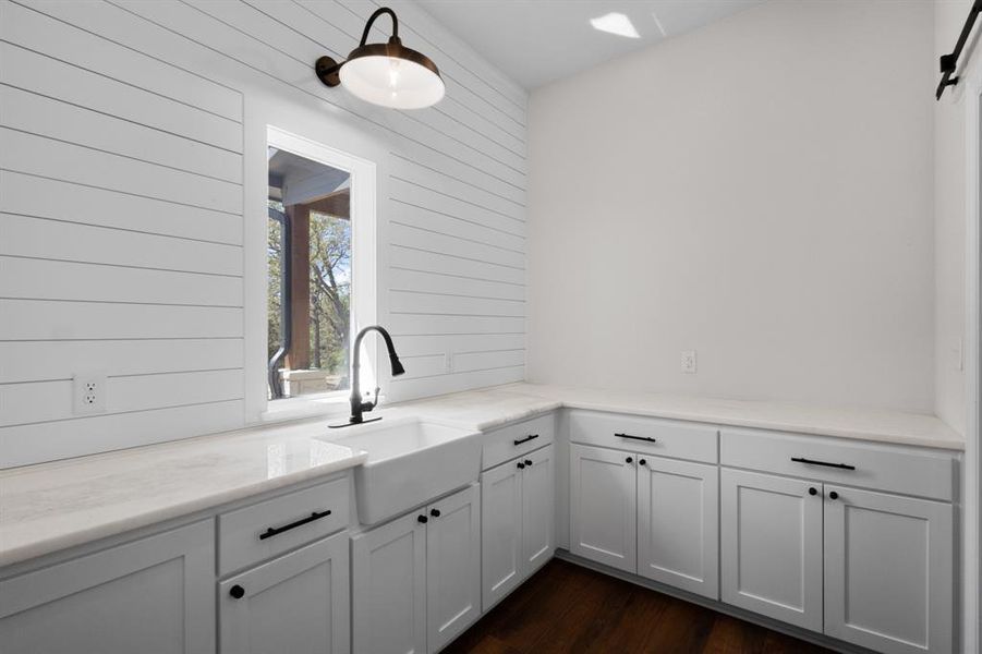 Bar featuring white cabinetry, dark wood-type flooring, and light stone countertops