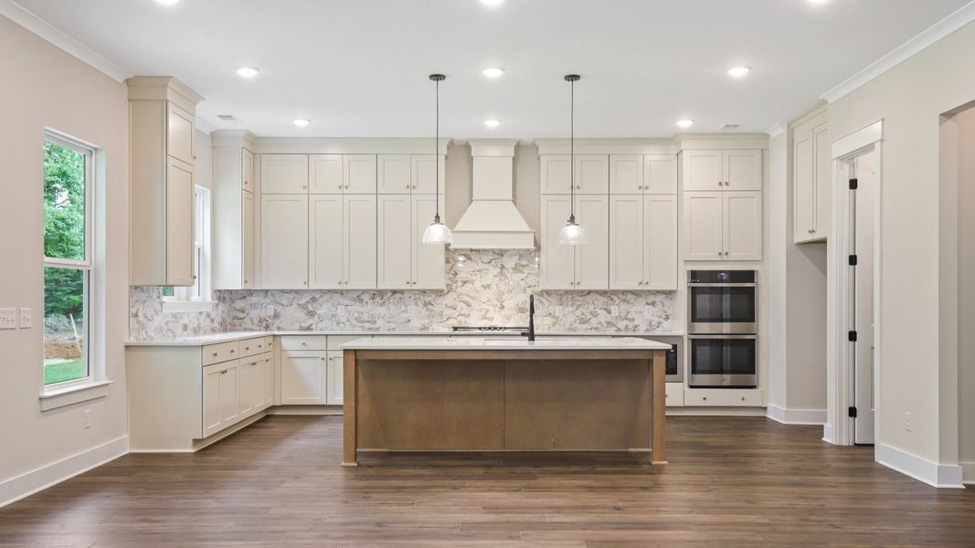 Kitchen with quartz countertops, tile backsplash, and pendant lighting Kitchen with quartz countertops, tile backsplash, and pendant lighting