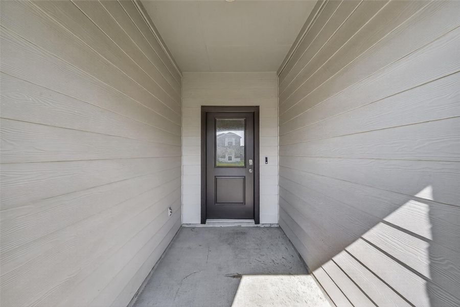 A charming covered front porch creates an inviting first impression for guests.