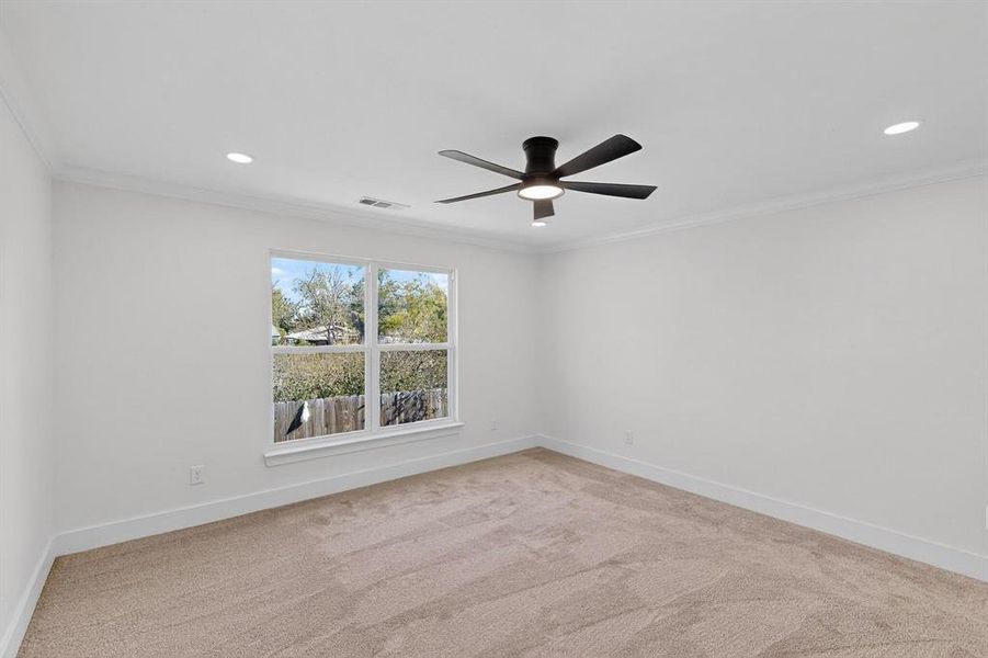 Spare room featuring ornamental molding, light colored carpet, recessed lighting, and a ceiling fan