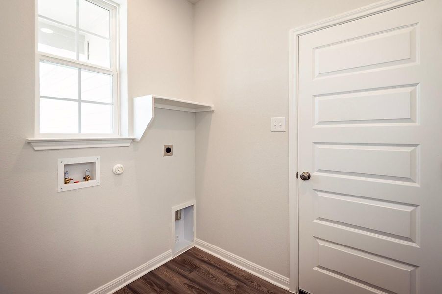 Laundry area with hookup for a gas dryer, hookup for an electric dryer, dark wood-style flooring, hookup for a washing machine, and baseboards Laundry area with hookup for a gas dryer, hookup for an electric dryer, dark wood-style flooring, hookup for a washing machine, and baseboards