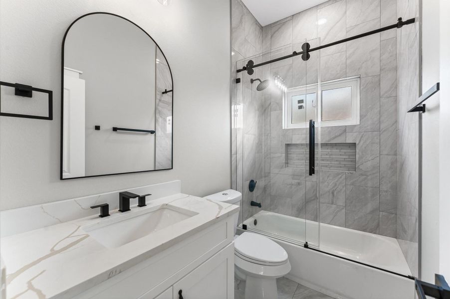 Secondary bath with modern vanity, tile finishes, and elegant design. Secondary bath with modern vanity, tile finishes, and elegant design.