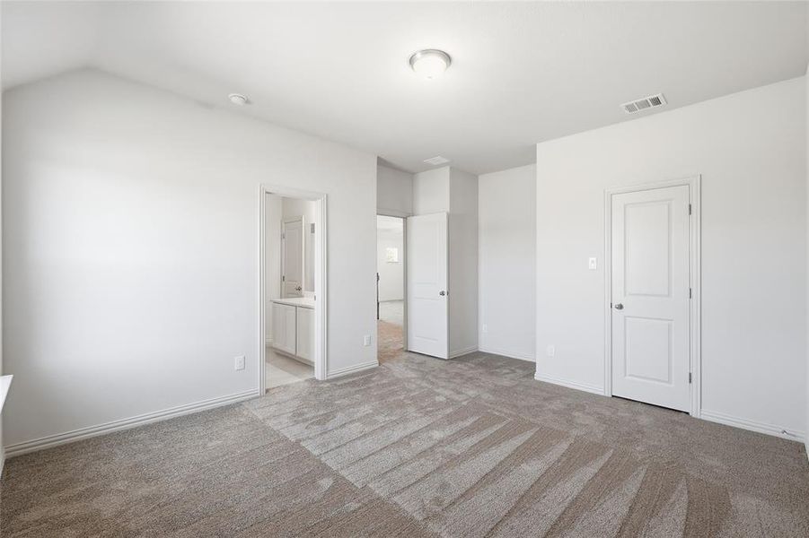 Unfurnished bedroom with ensuite bath and light carpet