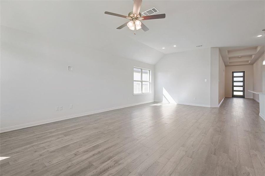 Unfurnished living room with wood finished floors, recessed lighting, ceiling fan, and vaulted ceiling