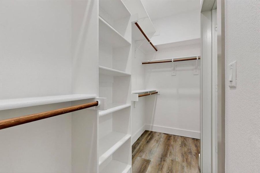 Walk in closet with light wood finished floors