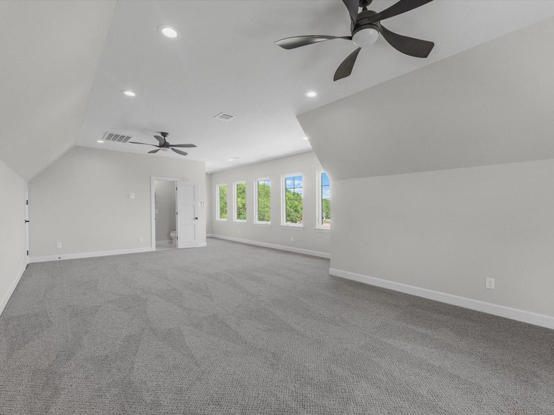 Spacious upstairs bonus room with multiple windows, ideal for a game room, media space, or flex living.