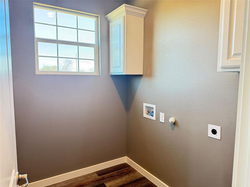 Laundry room with cabinets, dark hardwood / wood-style floors, hookup for a washing machine, and hookup for an electric dryer