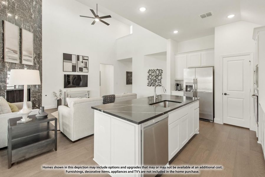 Open-concept kitchen with white island, dark countertops, and stainless appliances, open to living room with high ceilings Open-concept kitchen with white island, dark countertops, and stainless appliances, open to living room with high ceilings