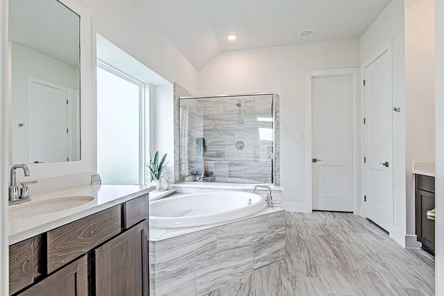Sleek and serene—this primary bath features a soaking tub, glass-enclosed shower, and beautiful tilework that elevates the entire space. Sleek and serene—this primary bath features a soaking tub, glass-enclosed shower, and beautiful tilework that elevates the entire space.