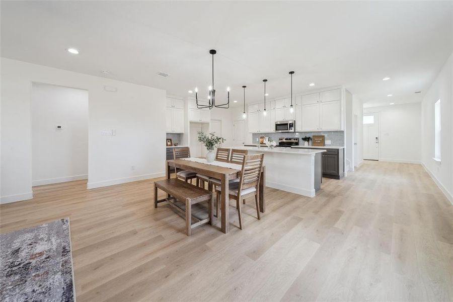 Dining area with a chandelier and light hardwood / wood-style floors