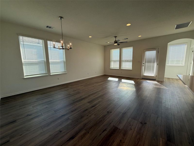 Unfurnished dining area featuring a ceiling fan, recessed lighting, dark wood-type flooring, and a chandelier Unfurnished dining area featuring a ceiling fan, recessed lighting, dark wood-type flooring, and a chandelier