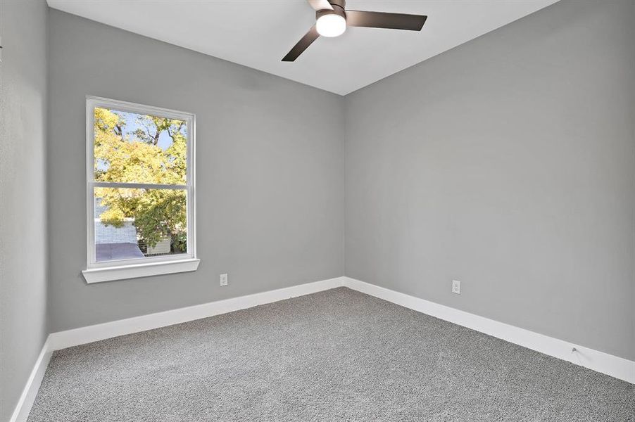 Carpeted spare room with ceiling fan