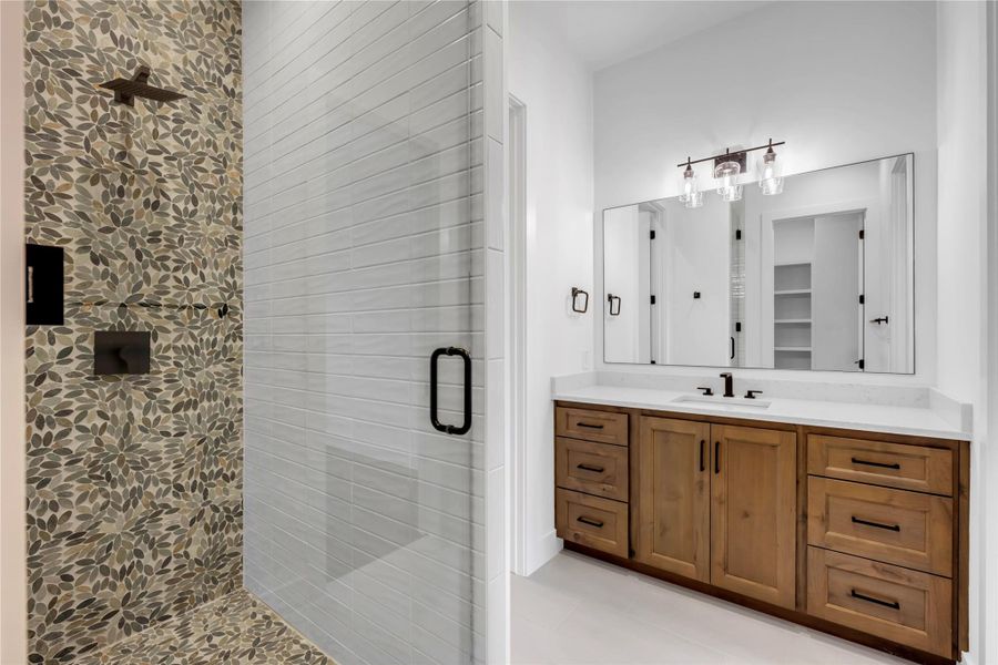 Bathroom featuring a stall shower, vanity, and light tile patterned flooring