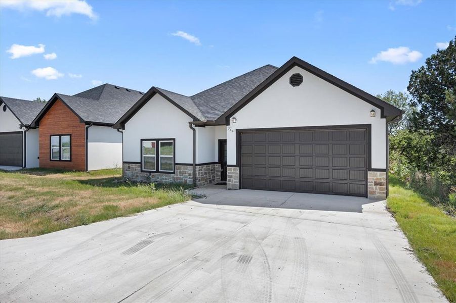 View of front of house featuring a garage and a front lawn