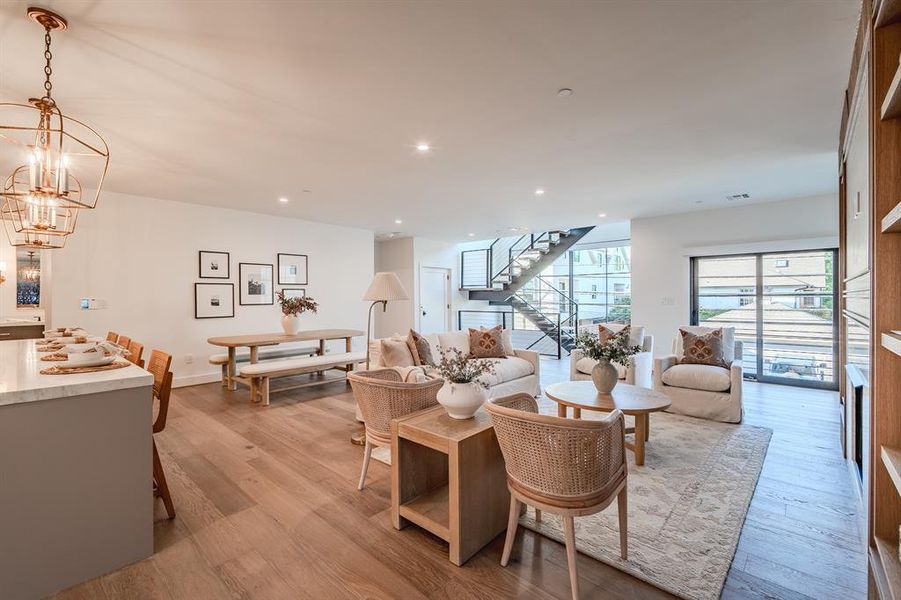 Living room with light wood-type flooring, recessed lighting, stairs, and a chandelier Living room with light wood-type flooring, recessed lighting, stairs, and a chandelier