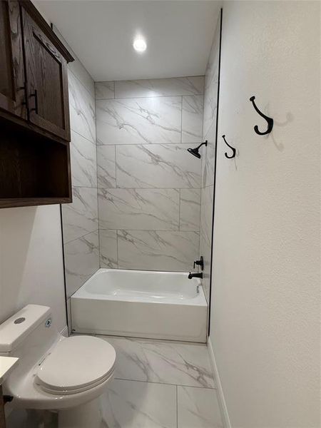 Full bath featuring light marble finish flooring and shower / tub combination Full bath featuring light marble finish flooring and shower / tub combination