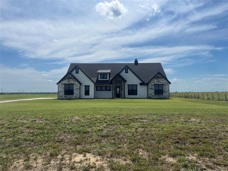 View of front of property with stone siding, a front yard, and a chimney View of front of property with stone siding, a front yard, and a chimney