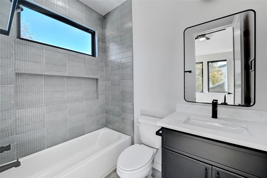 Bathroom featuring plenty of natural light, vanity, and washtub / shower combination