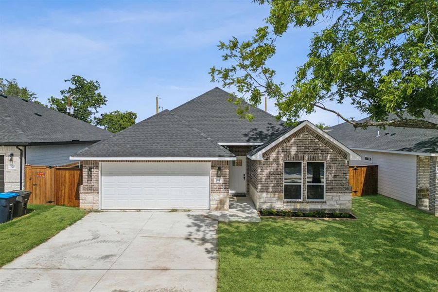 View of front of property featuring a garage and a front yard