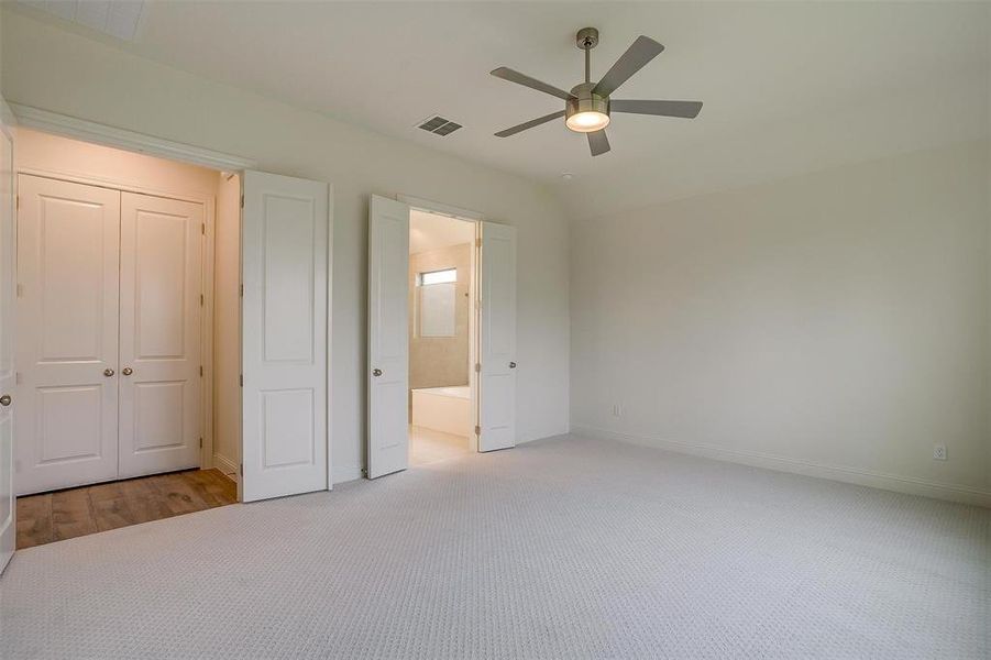 Unfurnished bedroom featuring a closet, light colored carpet, and ceiling fan