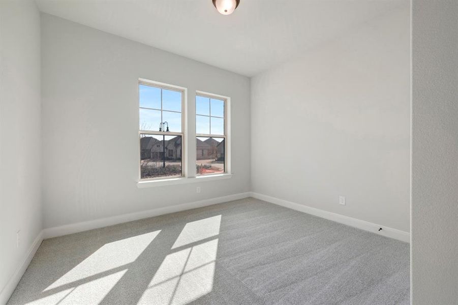 Empty room featuring light colored carpet and baseboards