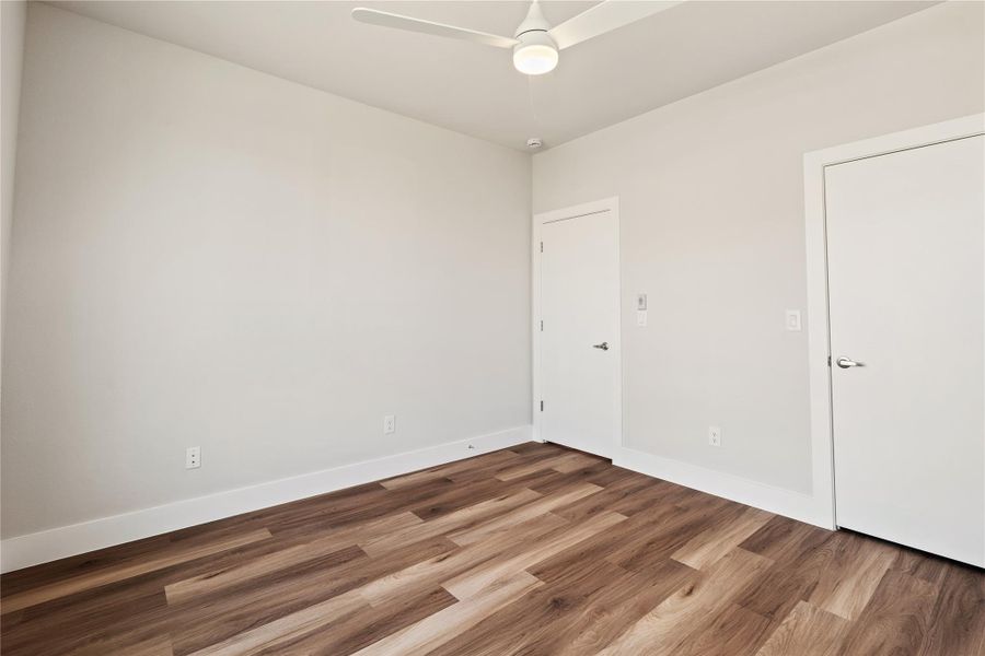 An additional view of the first-floor guest bedroom, highlighting the walk-in closet and clean, flexible layout.