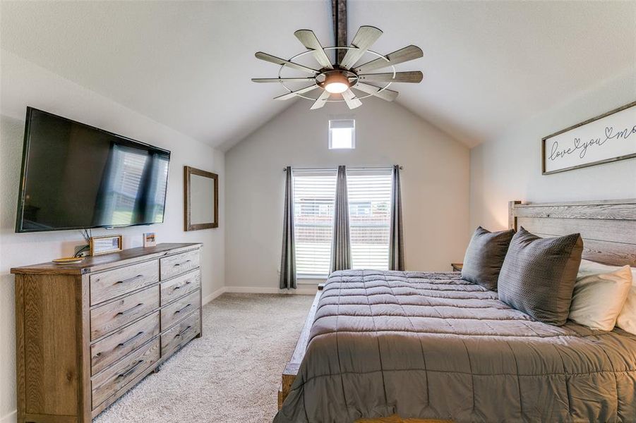 Primary bedroom with ceiling fan and lofted ceiling