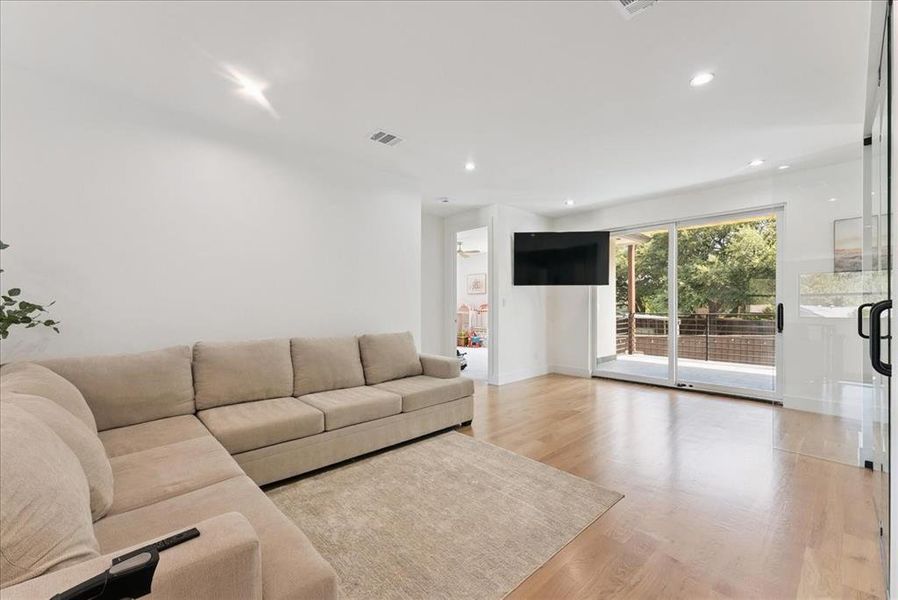 Living room with light wood finished floors and recessed lighting
