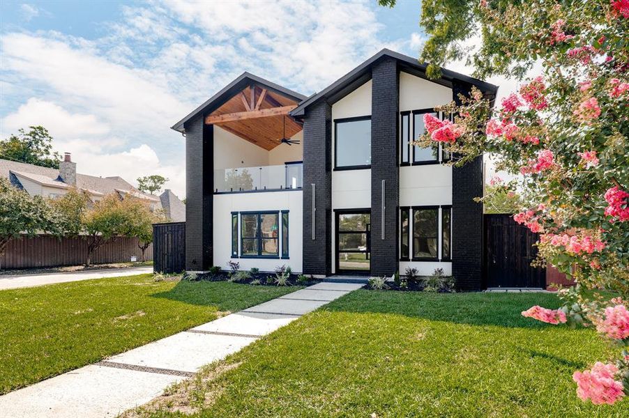 Modern home with ample balcony, brick siding, and stucco siding Modern home with ample balcony, brick siding, and stucco siding