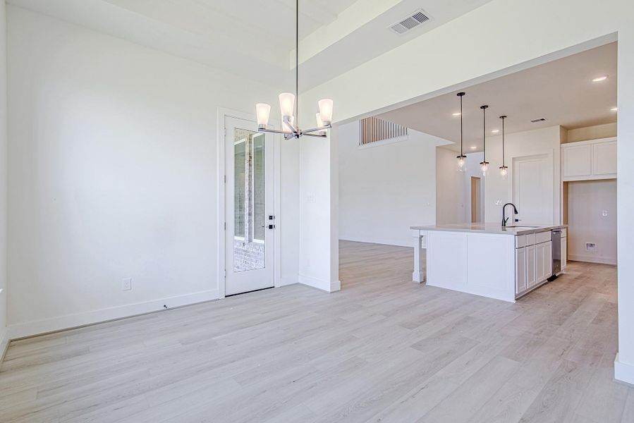 Open-concept dining space flows into the kitchen and living room with ease