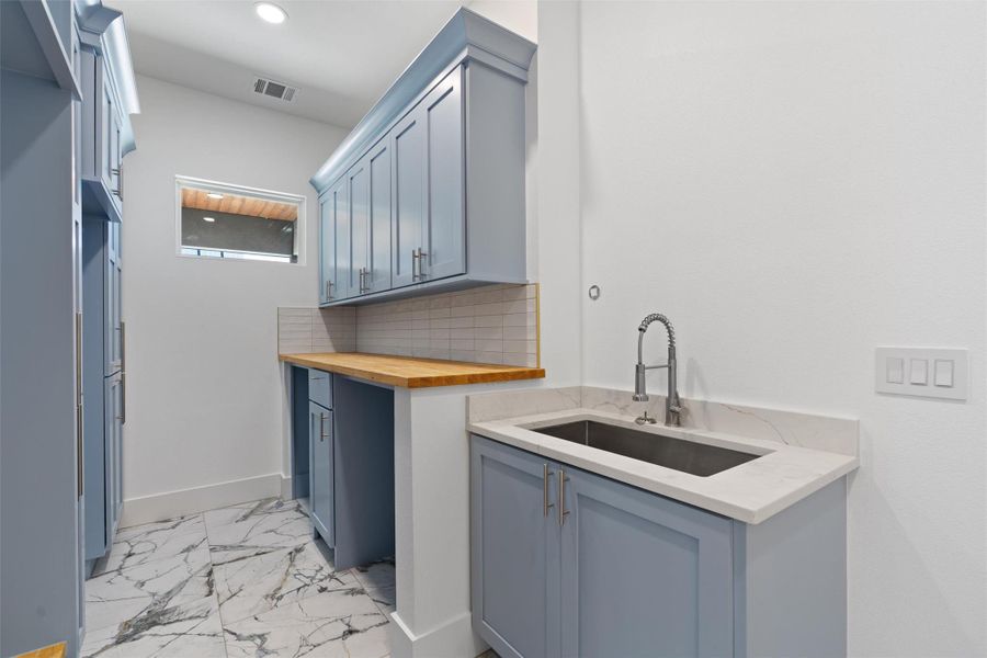 Laundry area with light marble finish flooring and recessed lighting