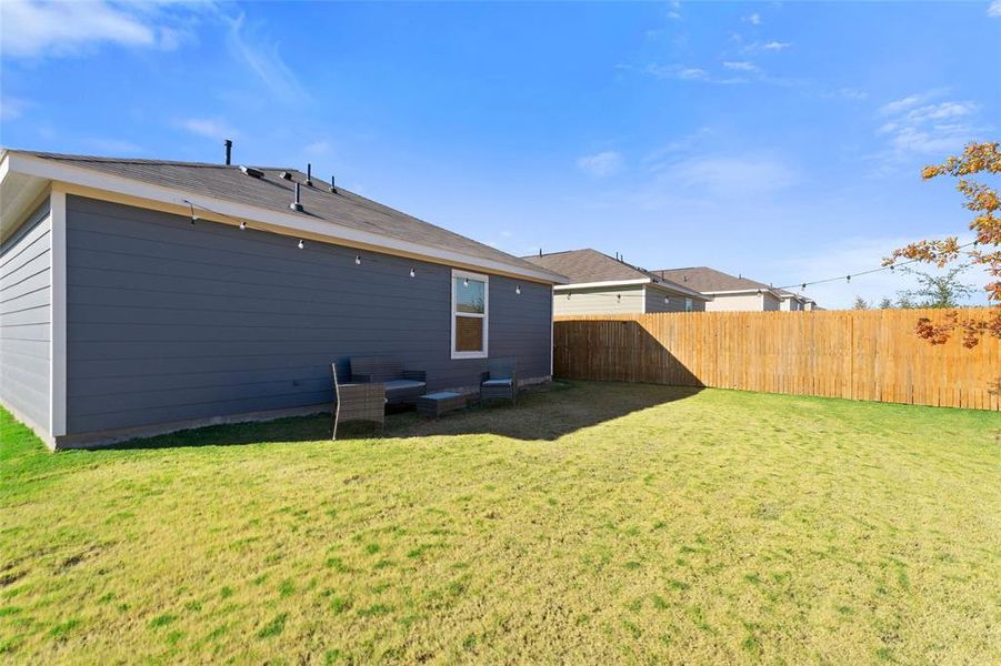 Rear view of property with a fenced backyard