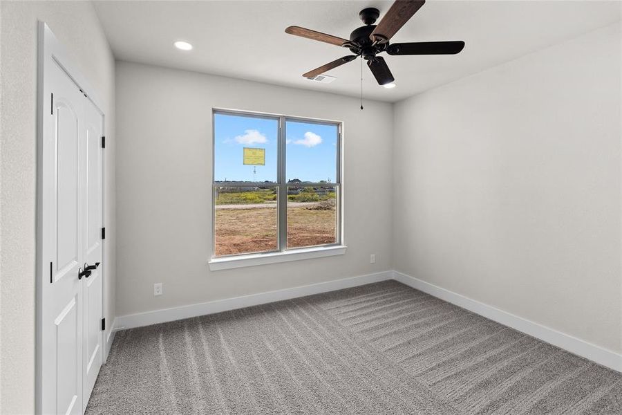 Carpeted spare room featuring ceiling fan