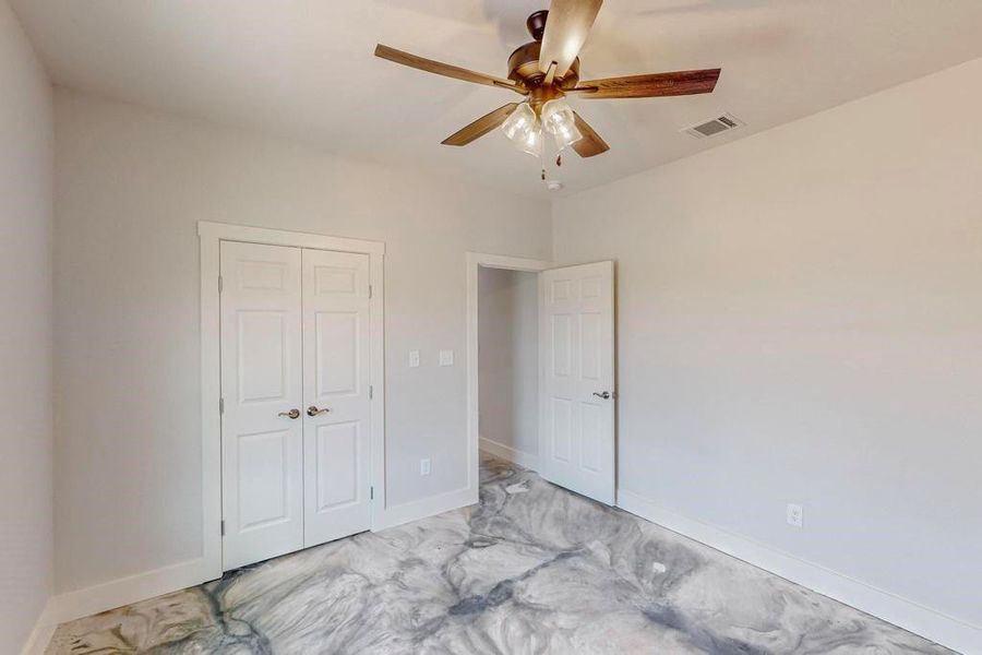 Unfurnished bedroom featuring a closet, ceiling fan, and light tile patterned flooring