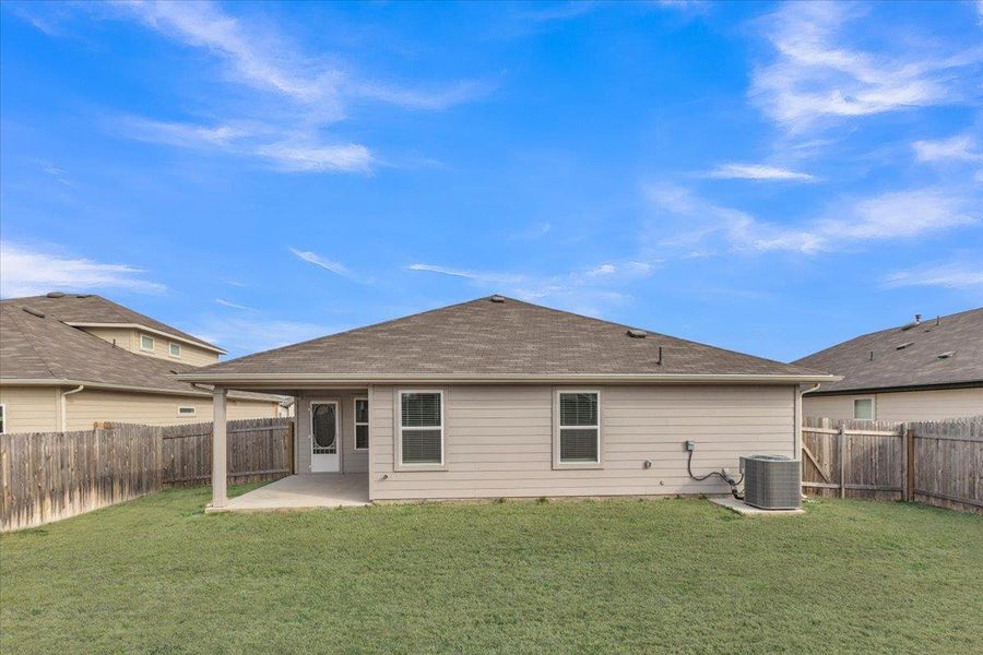 Back of property featuring a patio area, a fenced backyard, and roof with shingles