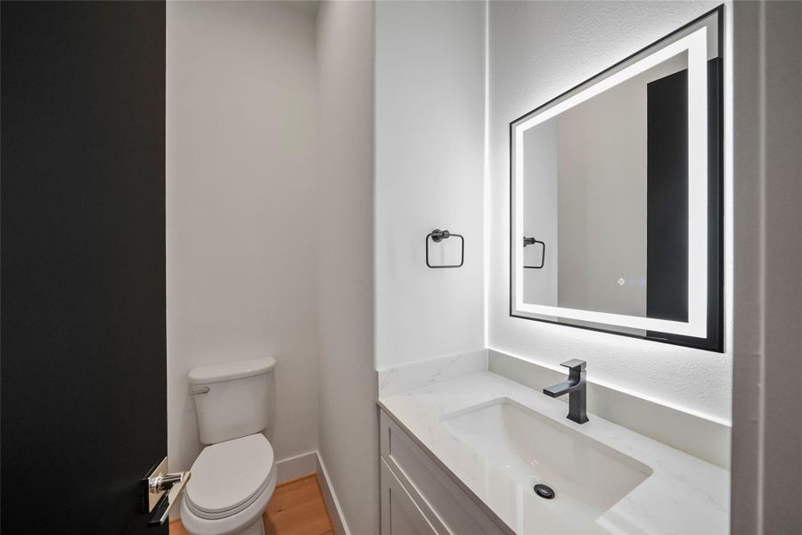Sophisticated powder room with a sleek LED vanity mirror for a modern touch. Sophisticated powder room with a sleek LED vanity mirror for a modern touch.